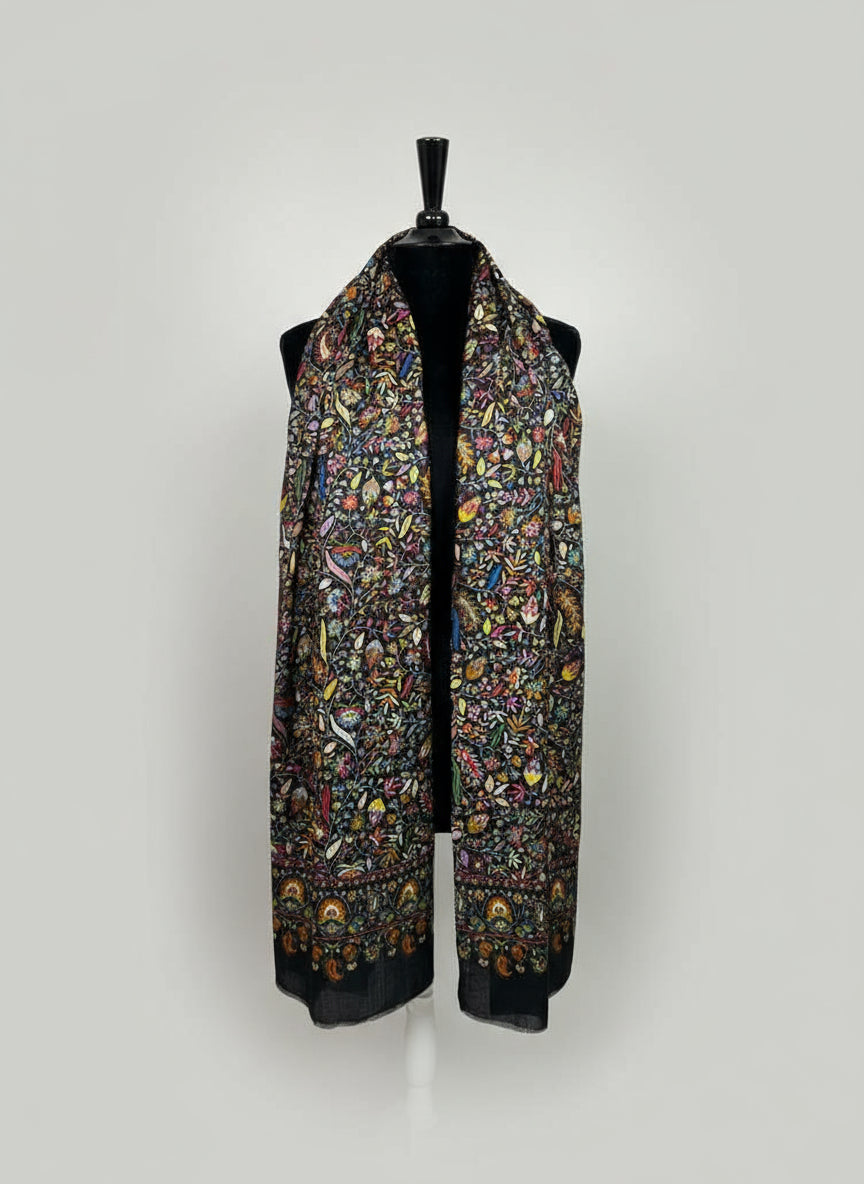 Colorful patterned scarf on a mannequin against a neutral background