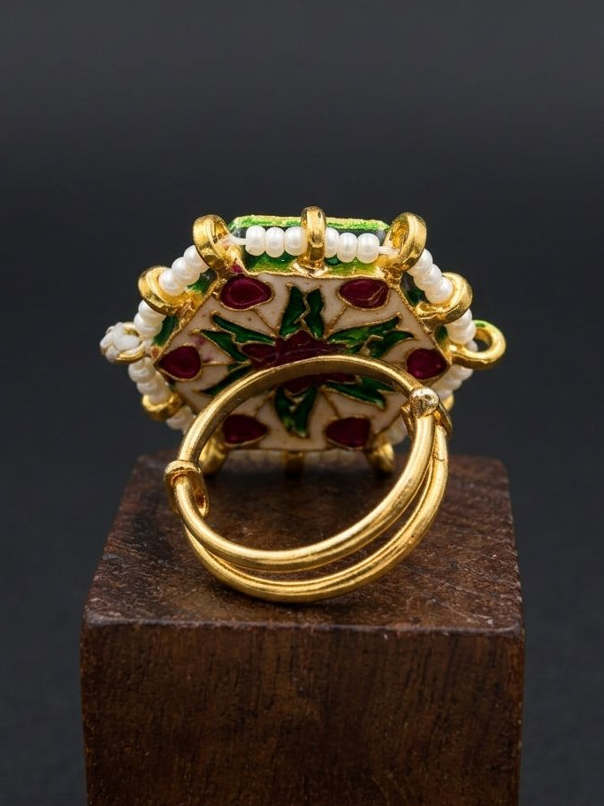 Decorative ring with gold, red, and green details on a dark background