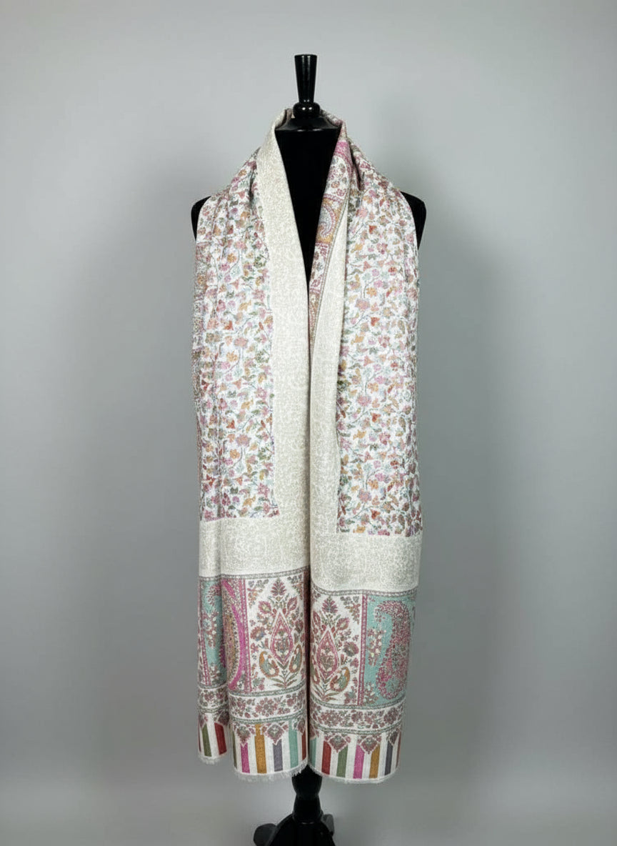 Mannequin wearing a floral patterned scarf with jewelry display in the background.