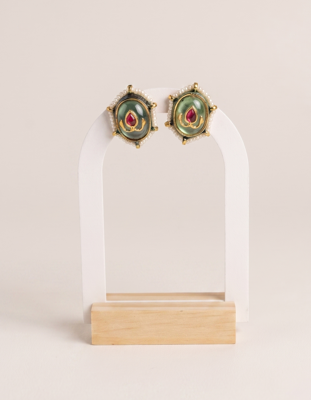 Pair of earrings on a clear stand with a white background