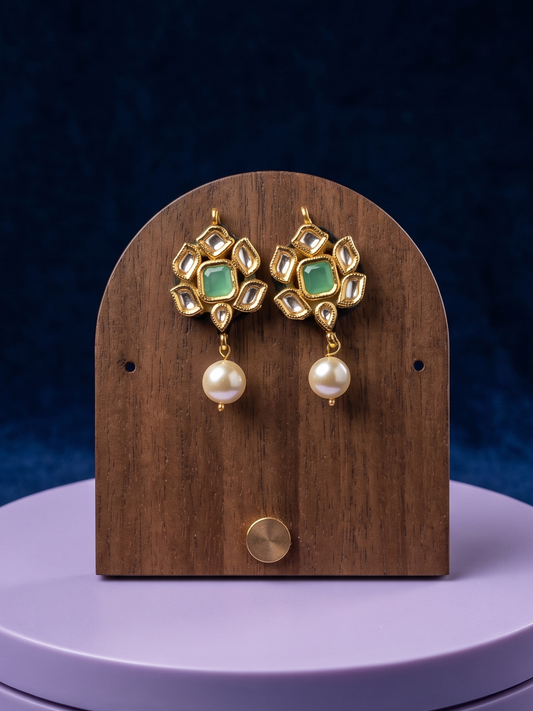 Handcrafted Kundan earrings featuring aventurine stones, luminous pearl drops, floral-inspired detailing, and radiant 22Kt gold plating for timeless elegance.