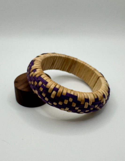 Woven bracelet with purple accents on a white background