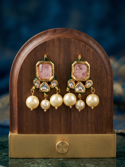 Ornate earrings on a wooden and gold stand with a blurred background