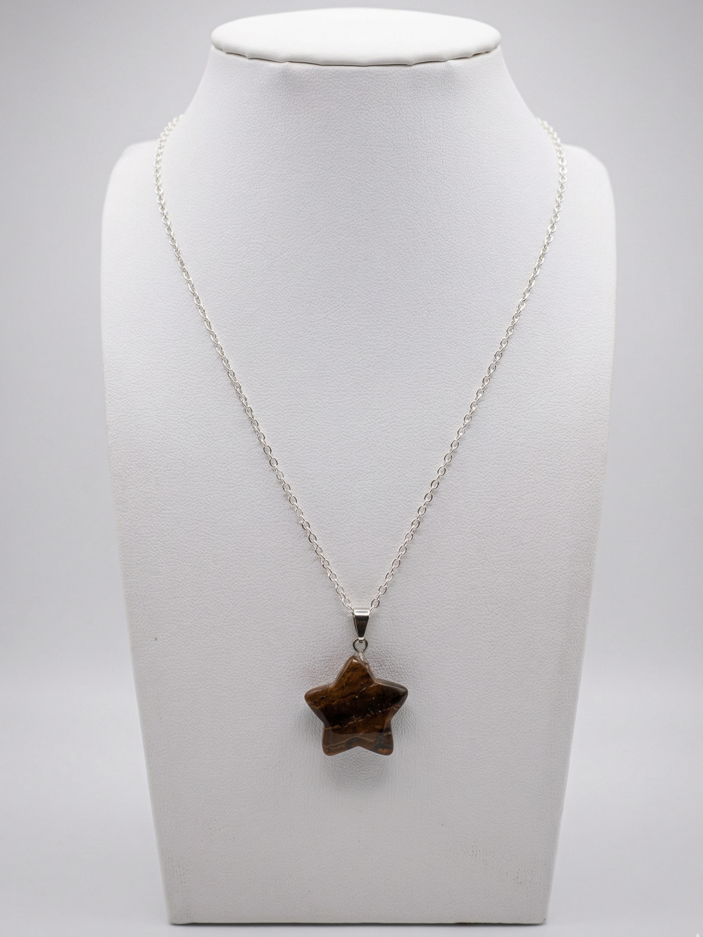 Necklace with a star-shaped pendant on a mannequin bust against a white background