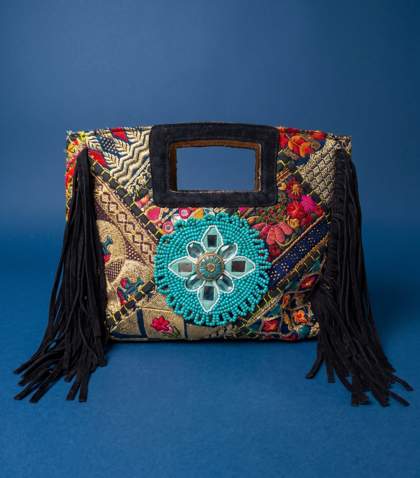 Colorful handbag with intricate patterns and fringes on a blue background