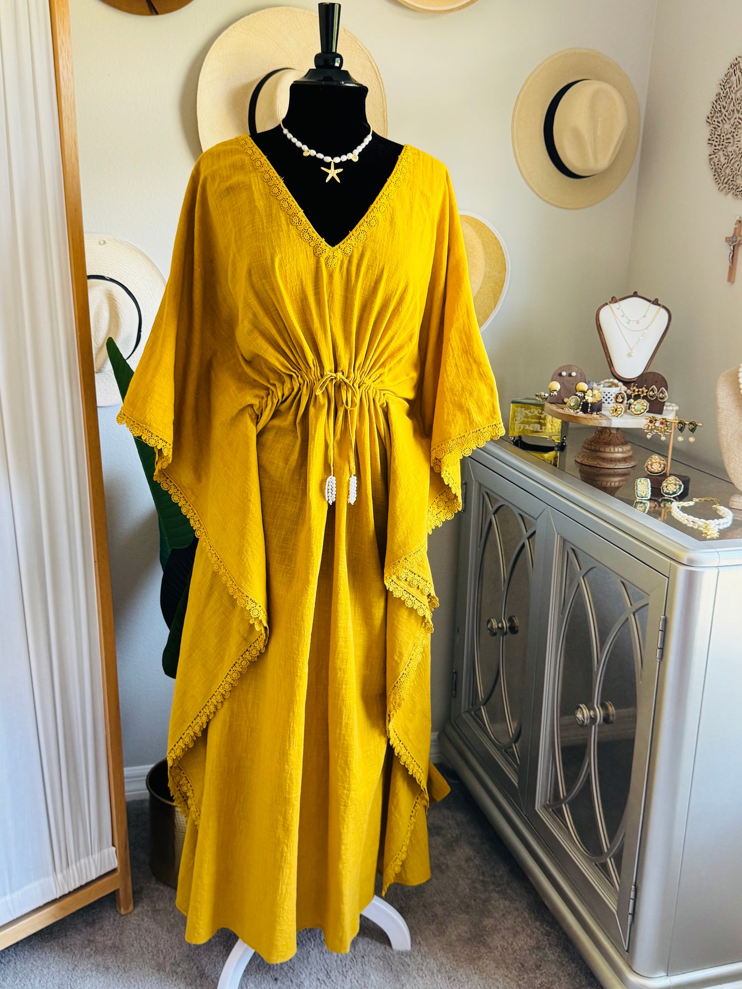 Yellow dress on a mannequin in a room with decorative items.