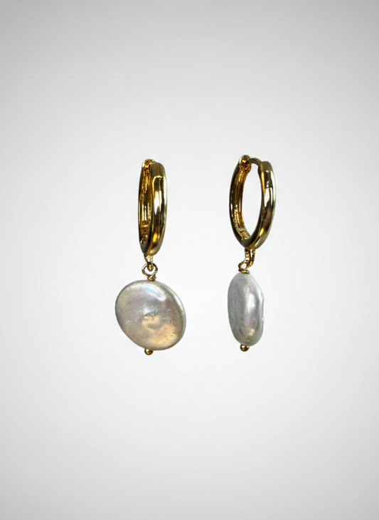 Pair of gold hoop earrings with pearl drops on a gray background