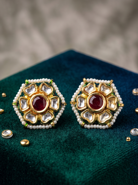 Handcrafted Kundan stud earrings featuring ruby center stones, floral crystal-inspired detailing, delicate pearl accents, and radiant 22Kt gold plating for timeless elegance.