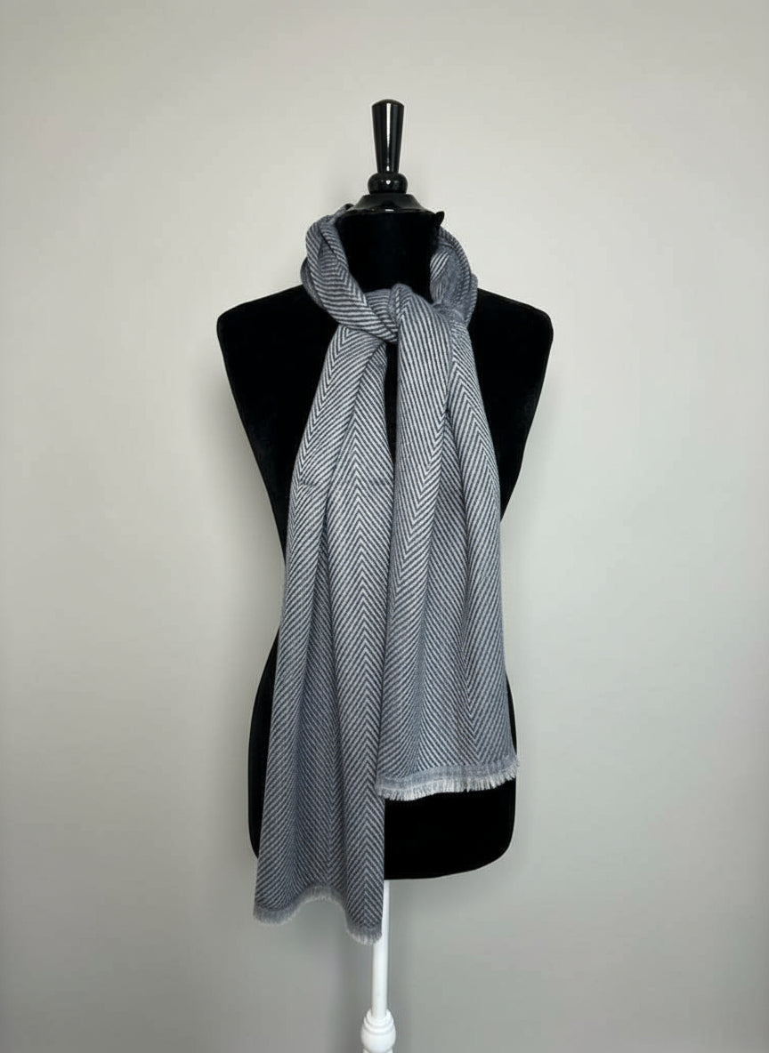 Gray scarf on a mannequin against a plain background