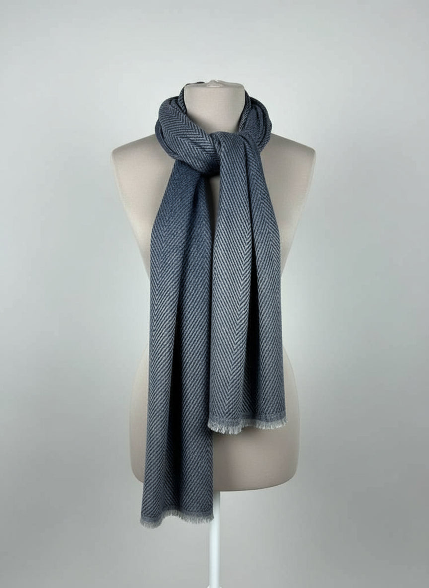 Mannequin wearing a gray scarf with a brown hat on a stand in the background.