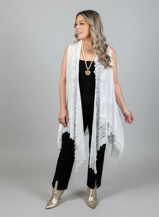 Woman wearing a white lace vest over a black outfit on a gray background