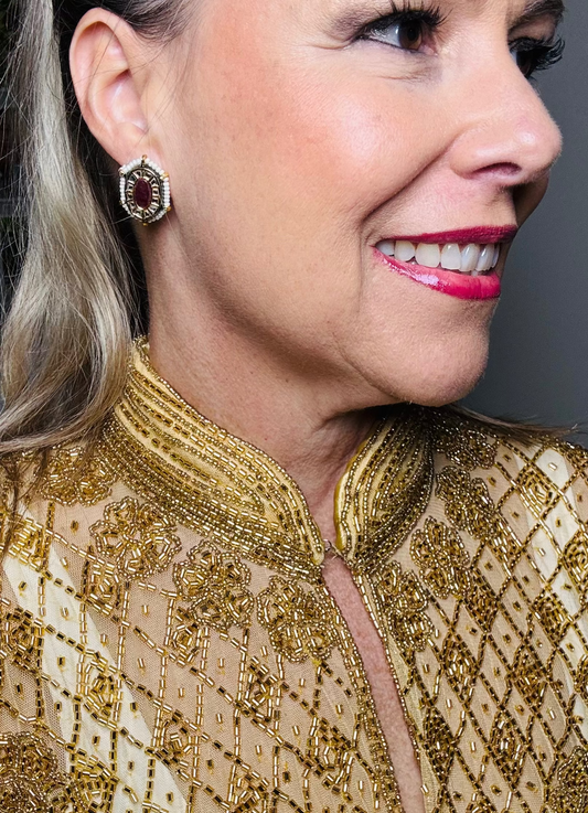 Woman wearing a gold beaded outfit with a gray background