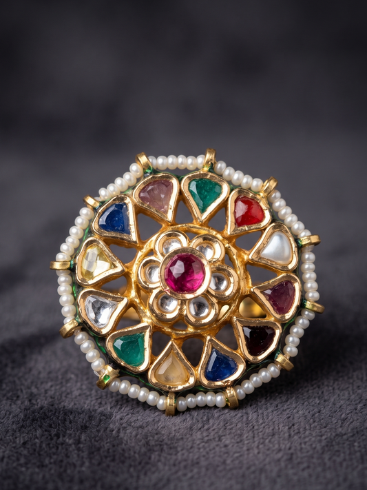 Decorative ring with gemstones and pearls on a dark background