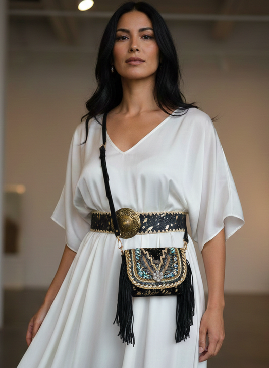 Woman wearing a white dress with a decorative belt and bag in an indoor setting