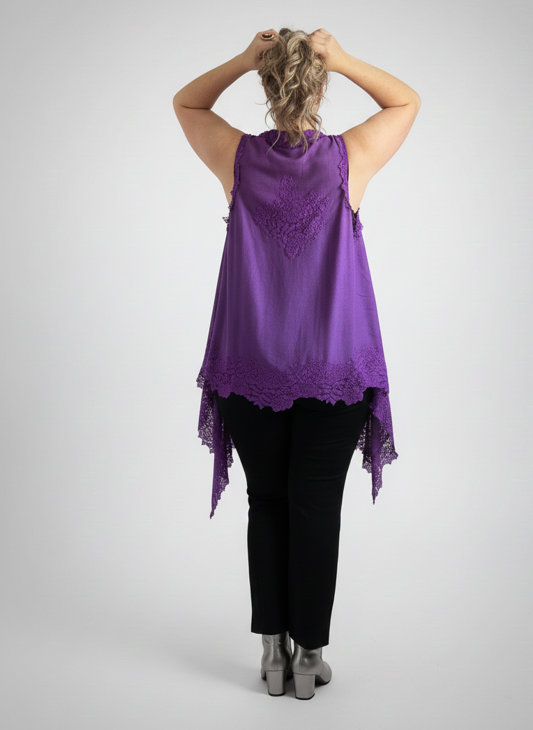 Person wearing a purple sleeveless top with lace details on a gray background
