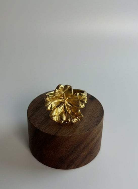 Gold ring on a wooden stand with marble surface