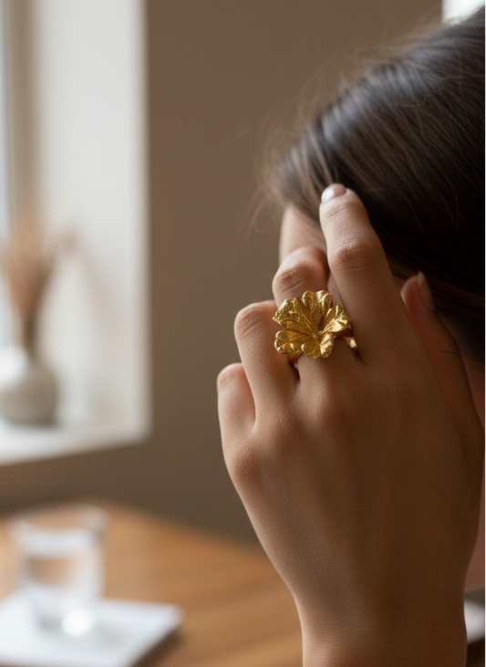 Person wearing a gold ring with a blurred indoor setting